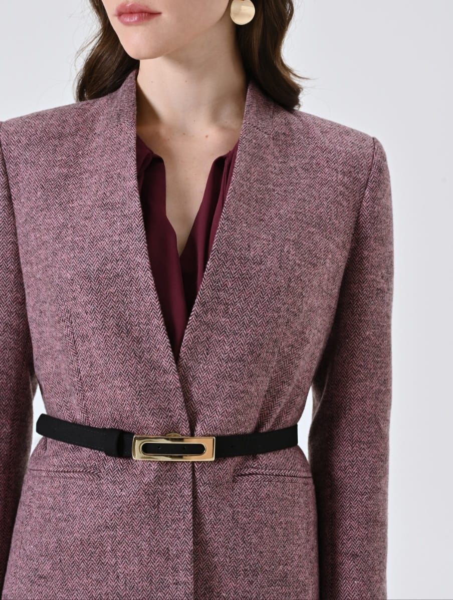 Detail van een roze tweedjasje met smalle zwarte riem.